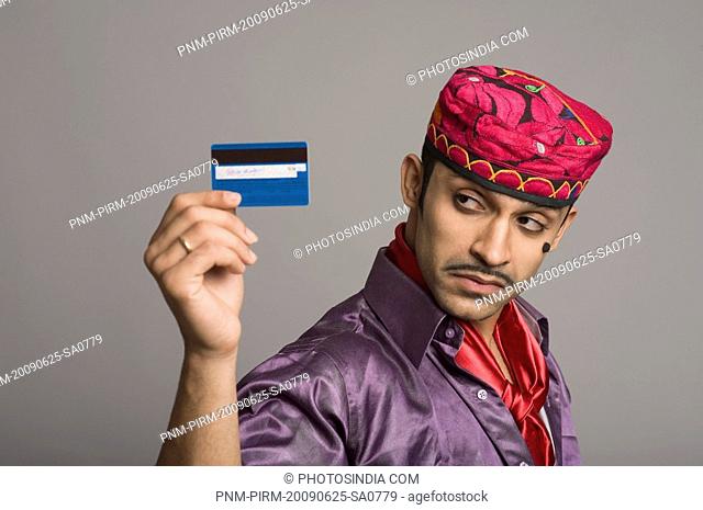 Actor portraying a tapori holding a credit card