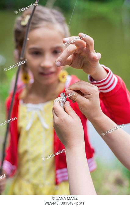 Germany, Girl with rod and small fish