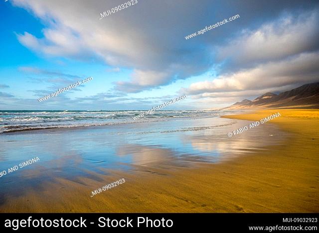 Lonely beach coloured and reflected with beautiful mountain background with cloudy sky - summer tropical vacation concept in free sandy scenic place with nobody...