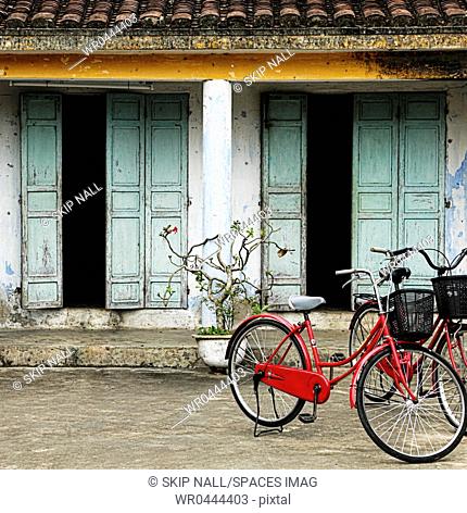Red Bikes Parked in Front of a Weathered Building