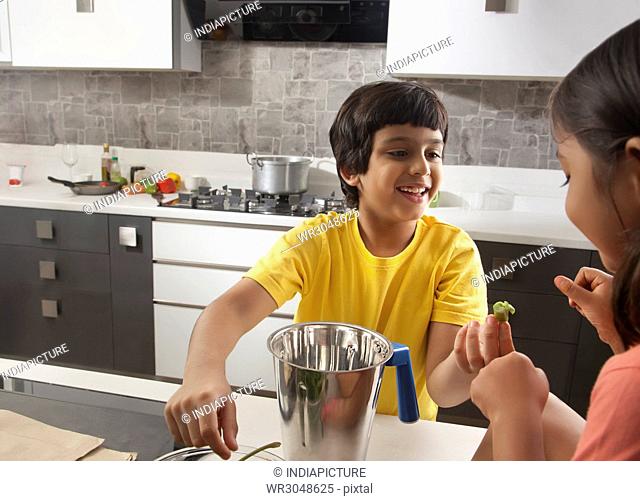Two children having fun together in kitchen