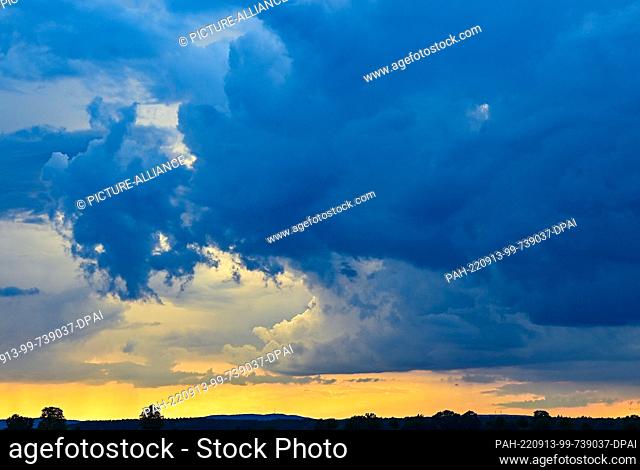 09 September 2022, Brandenburg, Petersdorf: Clouds of an impending thunderstorm darken the sky for sunset. Photo: Patrick Pleul/dpa