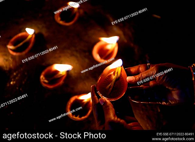 November 7, 2022, Kolkata, India: A woman holds an oil lamp on the occasion of Dev Deepavali, is the festival of Kartik Poornima, mainly celebrated in Varanasi