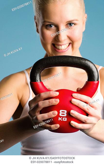 Happy girl and a kettlebell, focus on the kettlebell
