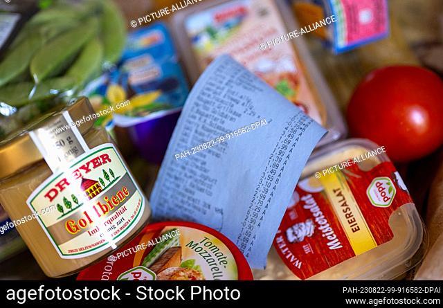 ILLUSTRATION - 21 August 2023, Berlin: A receipt lies in a shopping basket filled with various groceries. Photo: Monika Skolimowska/dpa