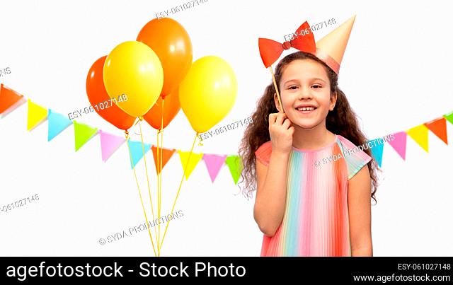 little girl in birthday party hat with bow