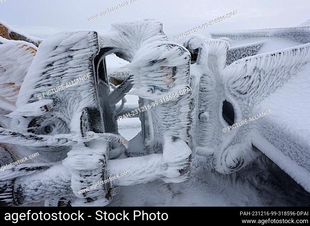 16 December 2023, Saxony-Anhalt, Schierke: Hoarfrost and snow cover an excavator on the Brocken. The mild temperatures of the past few days have caused the snow...