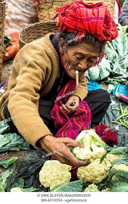 Smoking woman sells vegetables, from the Pao hilltribe, cauliflower, weekly market, Kalaw, Shan State, Myanmar, Burma