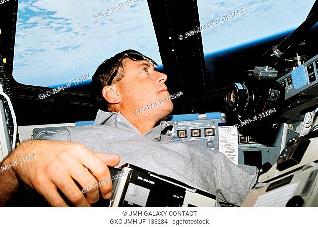 Astronaut Michael A. Baker, STS-68 mission commander, eyes a photographic target of opportunity on Earth. Baker was joined by five other NASA astronauts for...