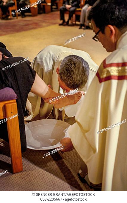 The robed pastor of St. Timothy's Catholic Church, Laguna Niguel, CA, washes the feet of parishioners on Holy Thursday mass in memory of Christ washing the feet...