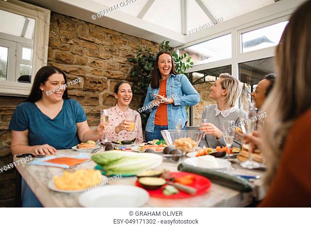 Small group of female friends preparing a healthy lunch inside of a conservatory on a weekend away