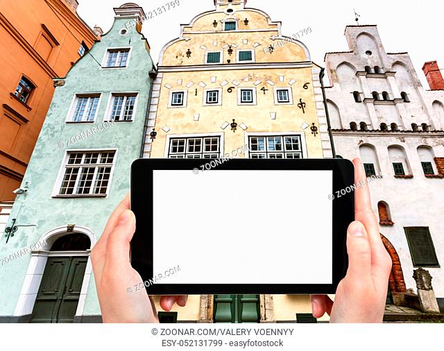 travel concept - tourist photographs Three Brothers, early Renaissance style houses, on Maza Pils iela in Old Riga Town Latvia in autumn on tablet with cut out...