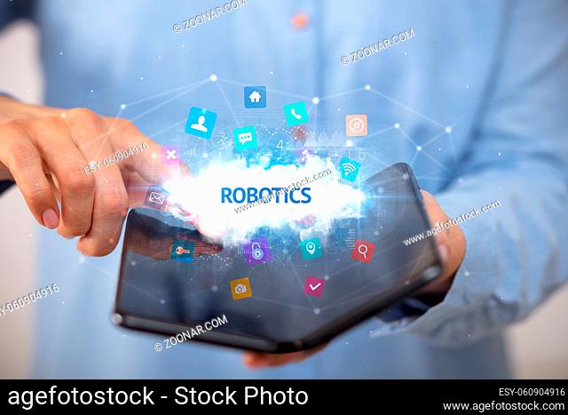 Businessman holding a foldable smartphone with ROBOTICS inscription, technology concept