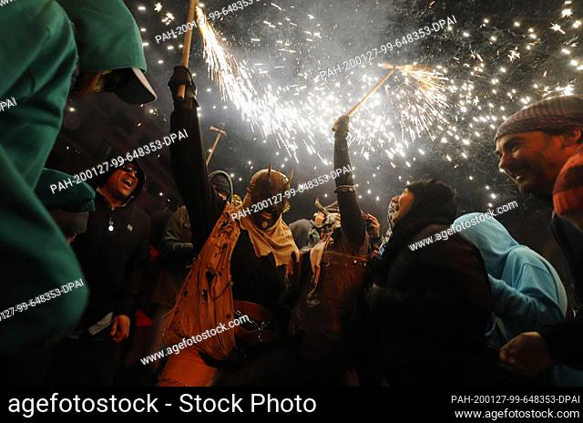 26 January 2020, Spain, Palma: Two people dressed as devils take part in the traditional Correfoc (firewalking) in the local fiesta of Palma de Mallorca