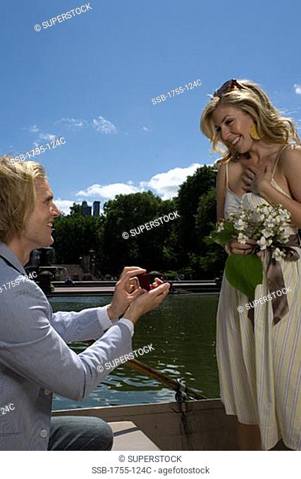 Young man proposing to a young woman and smiling, Central Park, Manhattan, New York City, New York, USA