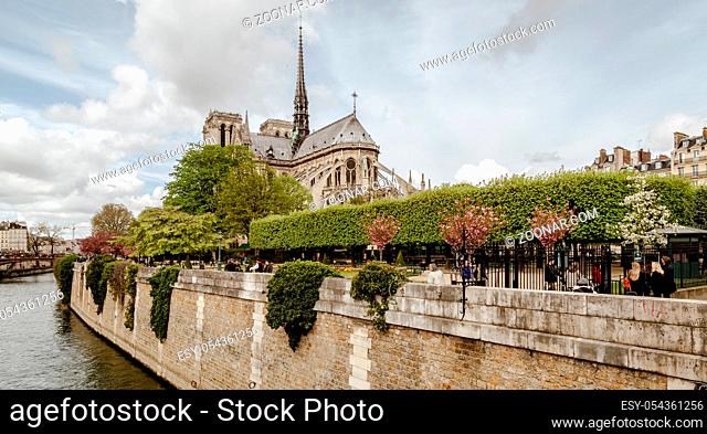 Paris, France, April 1, 2017: Apse of Notre-Dame de Paris and La fontaine de la Vierge from Square Jean-XXIII. Built in French Gothic architecture