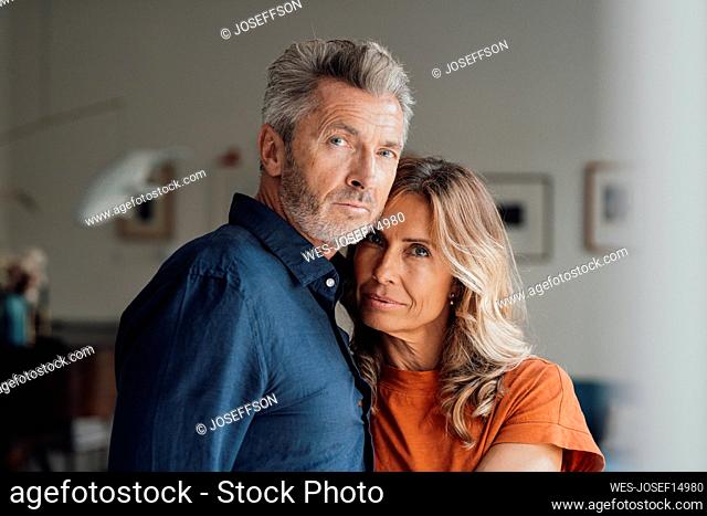 Mature woman embracing man in living room at home