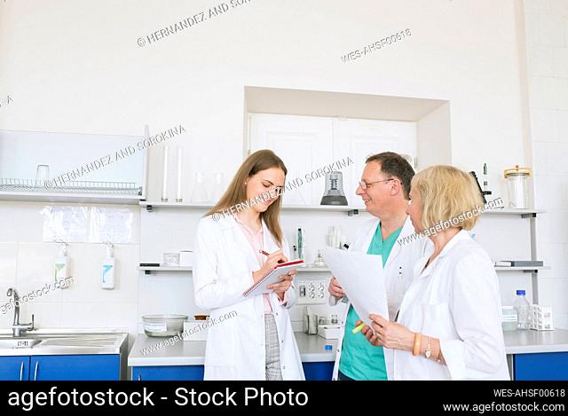 Scientists in white coats working together in lab