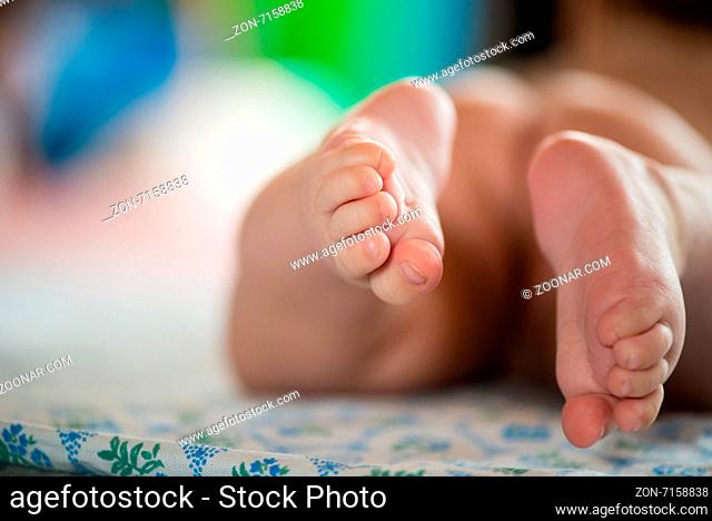 Close-up of tiny baby feet. Tiny foot of newborn baby in soft selective focus
