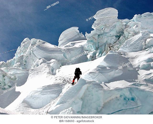 Climber between bizarre ice sculptures of Khumbu Icefall above Base Camp, Mount Everest, Himalaya, Nepal
