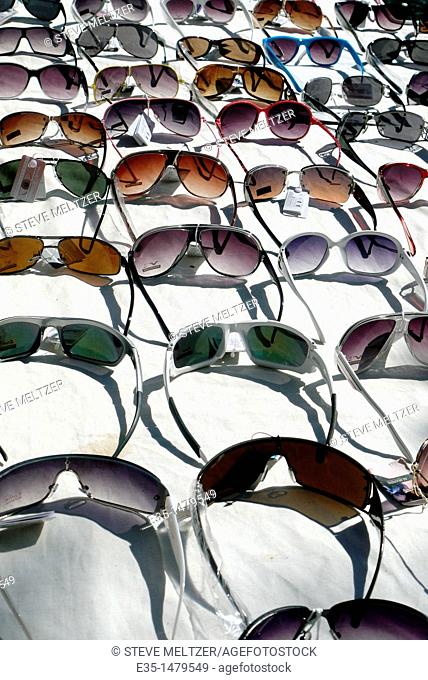 An assortment of sunglasses for sale at an outdoor market