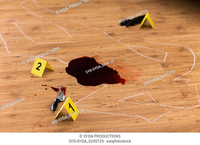 chalk outline and knife in blood at crime scene