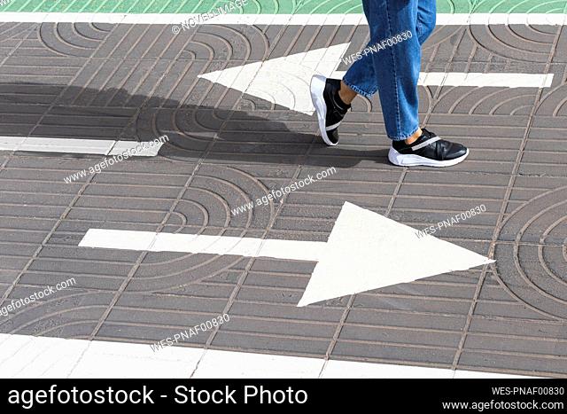 Woman walking on road during sunny day
