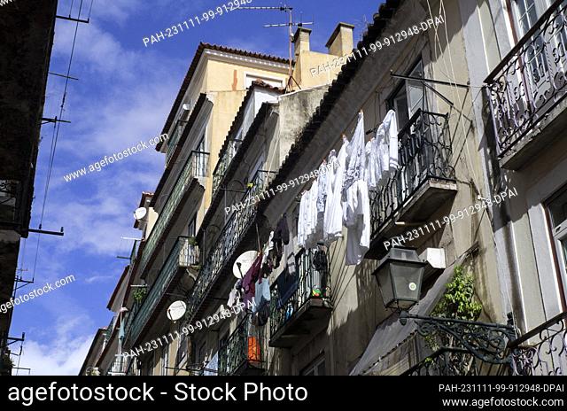 PRODUCTION - 27 October 2023, Portugal, Lissabon: White laundry hangs outside to dry on a washing line in front of a balcony of a residential building in...