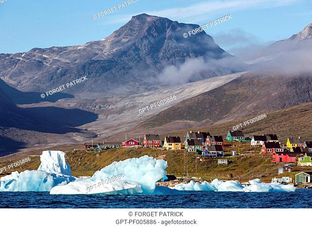 ICEBERGS THAT SEPARATED FROM THE GLACIER SNOUTS IN THE FJORD IN FRONT OF THE COLORFUL WOODEN HOUSES OF THE VILLAGE OF NARSAQ, GREENLAND