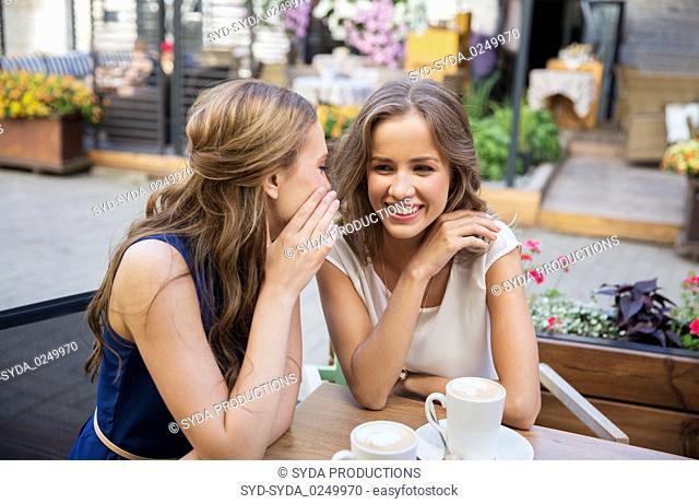 happy young women drinking coffee at outdoor cafe