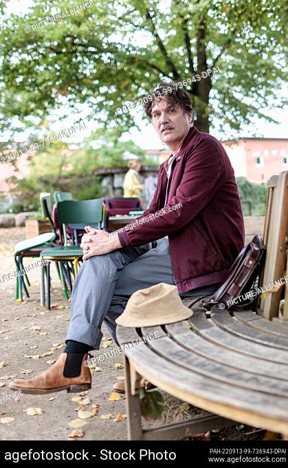 PRODUCTION - 12 September 2022, Hamburg: Frank Spilker, German musician, songwriter, novelist and singer of the band Die Sterne is sitting on a bench in his...