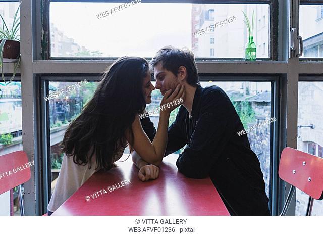 Young couple in love sitting at table at the window