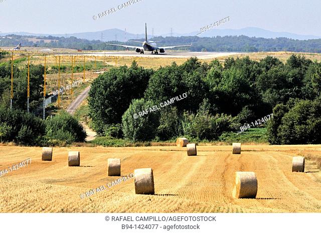 Plane and straw rolls. Girona-Costa Brava Airport, at 12.5 km southwest of the city of Girona, next to the small village of Vilobí d'Onyar. Girona