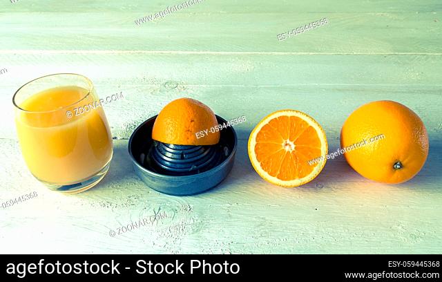 Saftpresse für Orangensaft und Orange auf Holztisch