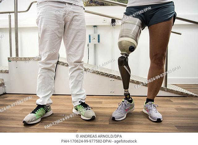 An orthopaedic technician stands next to a woman with a leg prothesis of the type 'Genium' of the company Ottobock in Frankfurt/Main, Germany, 16 May 2017