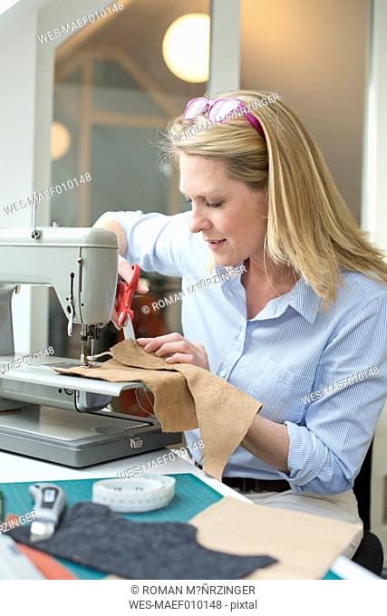 Woman with sewing machine tailoring