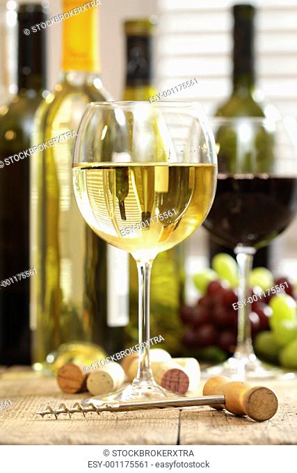 Glasses of wine with bottles in background