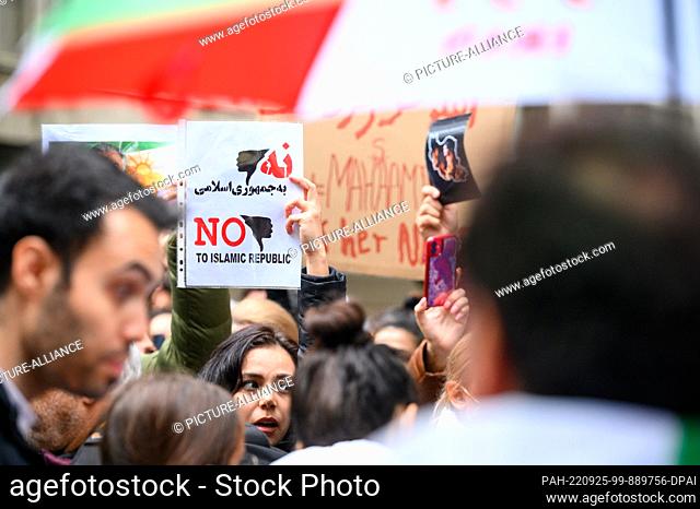 24 September 2022, Hamburg: People hold flags and signs reading, among other things, ""NO to islamic republic"" at a solidarity rally following the death of...