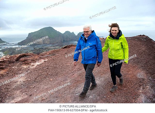 13 June 2019, Iceland, Westmännerinseln: Federal President Frank-Walter Steinmeier and his wife Elke Büdenbender stand on the crater rim of the Eldfell volcano