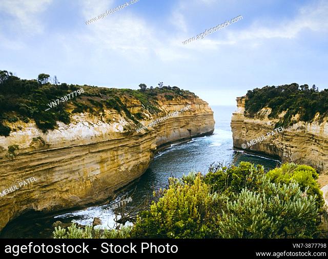 Loch Ard Gorge lookout with old airplane flying by in the distance, Port Campbell National Park, Great Ocean Road, Victoria, Australia