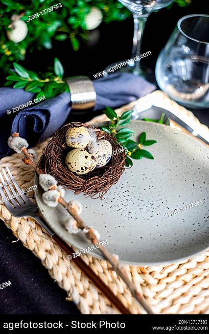 Festive table setting for Easter holiday dinner decorated with flowers and eggs
