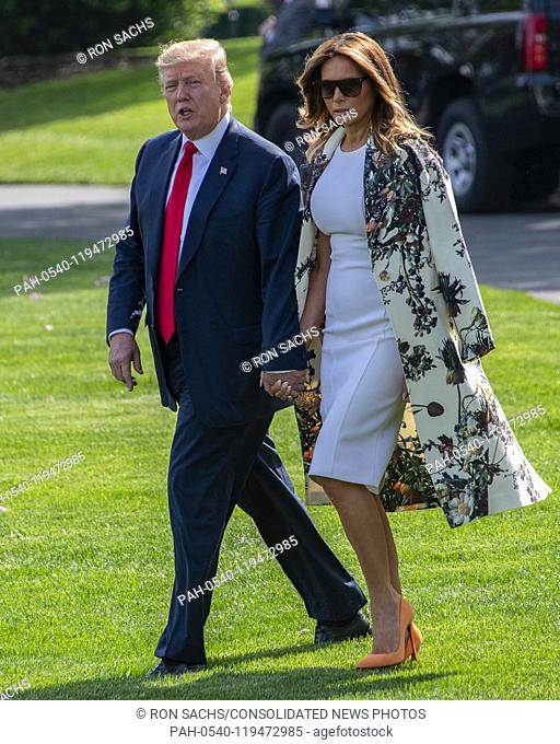 United States President Donald J. Trump and First lady Melania Trump walk across the South Lawn, avoiding the assembled media as they depart the White House in...