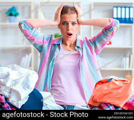The sad woman ironing clothing at home