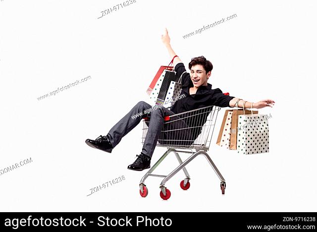 Young man with shopping cart and bags isolated on white