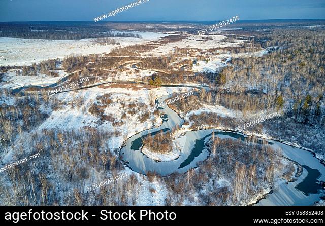 Aerial photo of Koen river under ice and snow. Beautiful winter landscape. Novosibirsk, Siberia, Russia