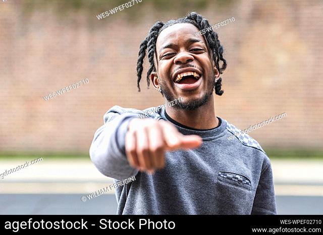 Laughing young man, pointing at camera