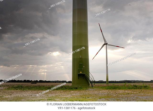 Wind turbine with a dramatic sky and rays of sunlight, shot in North-Rhine Westfalia, Germany