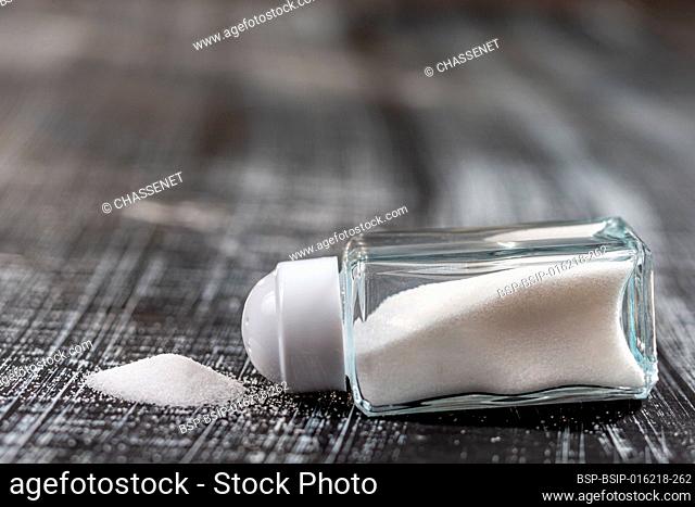 Close-up of fine salt contained in a glass salt shaker on a black background