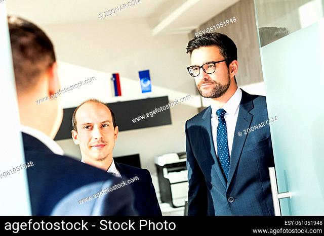 Group of confident business people greeting with a handshake at business meeting in modern office. Closing the deal agreement by shaking hands