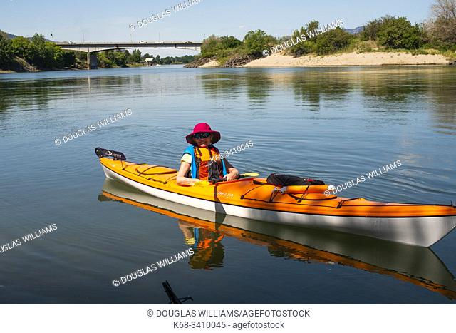 A woman kayaks on the Thompson River in Kamloops, BC, Canada